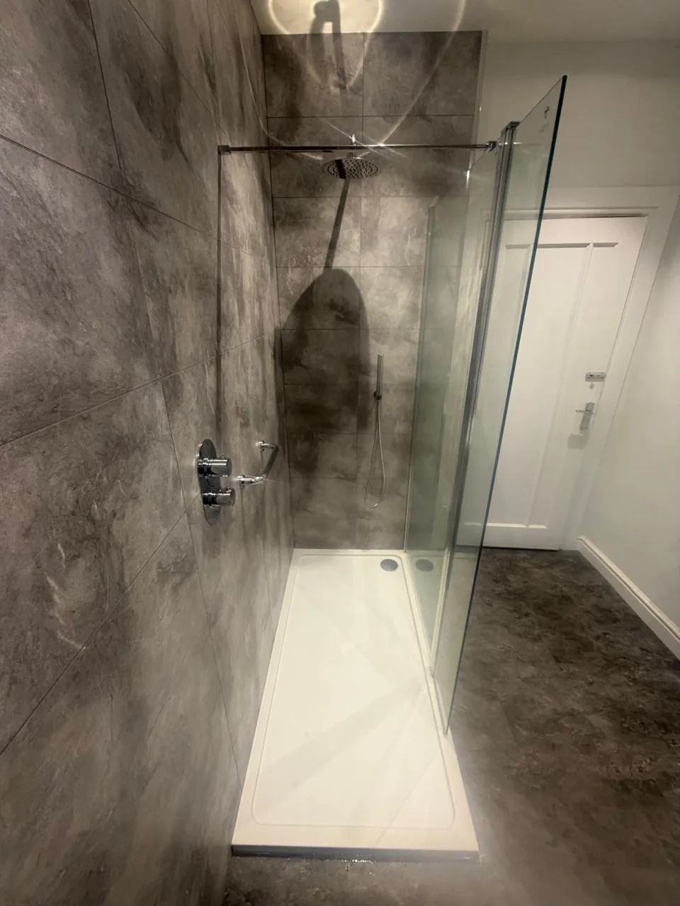 Long shower tray with grey wall panels